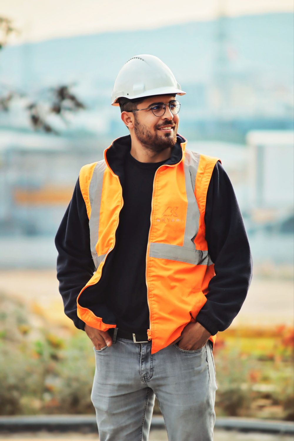 A construction worker wearing a hard hat and safety vest on a job site