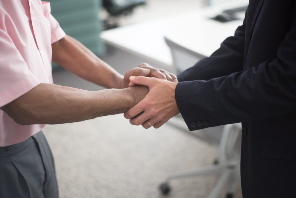 Two colleagues shaking hands in an office