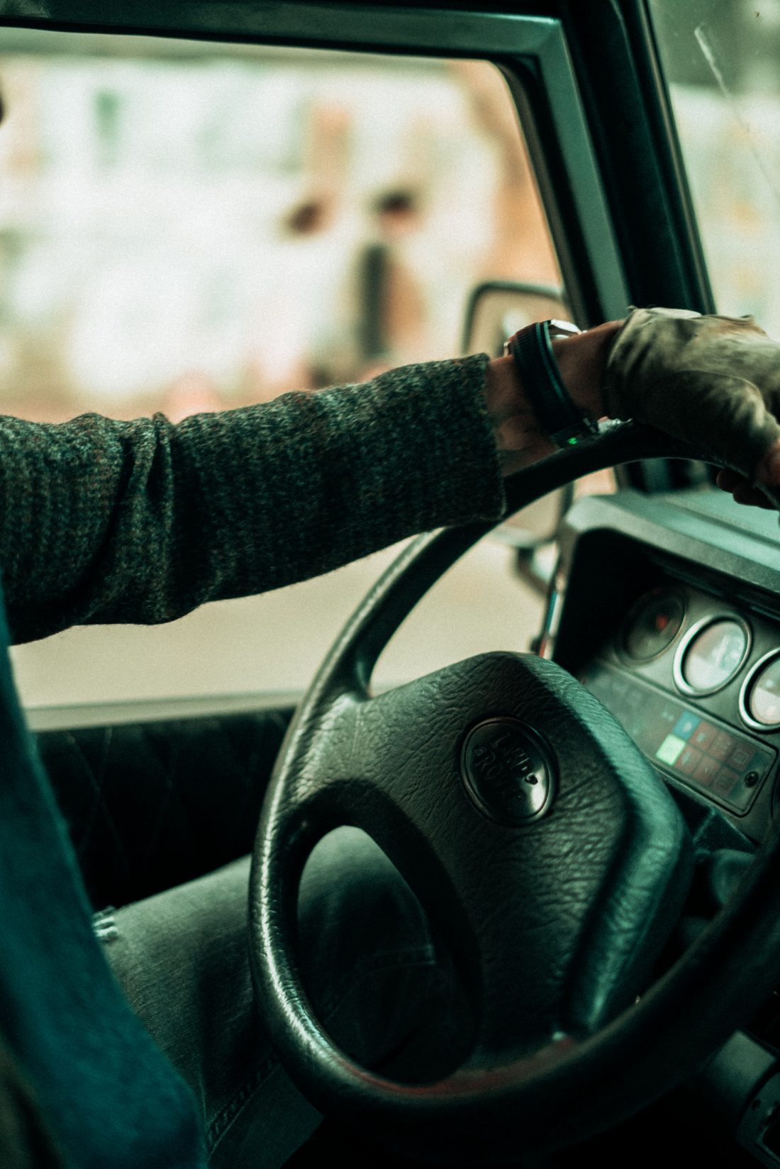 A driver with both hands on the steering wheel of a car