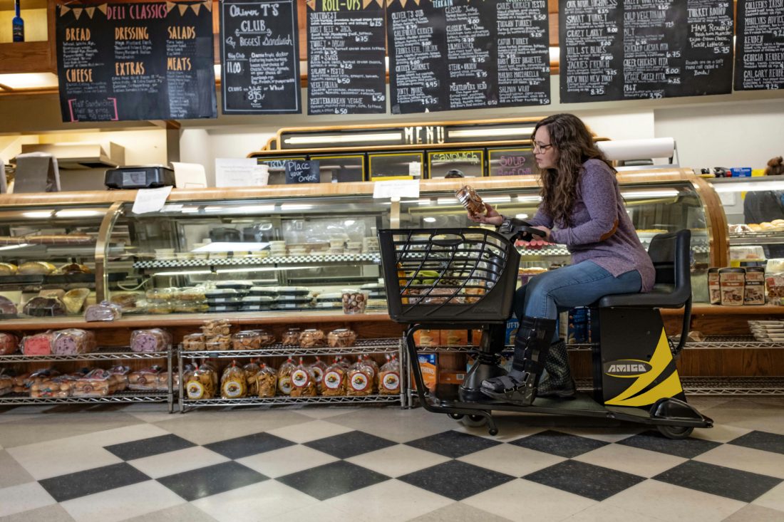 A person seated on a mobility scooter inside a neighborhood cafe