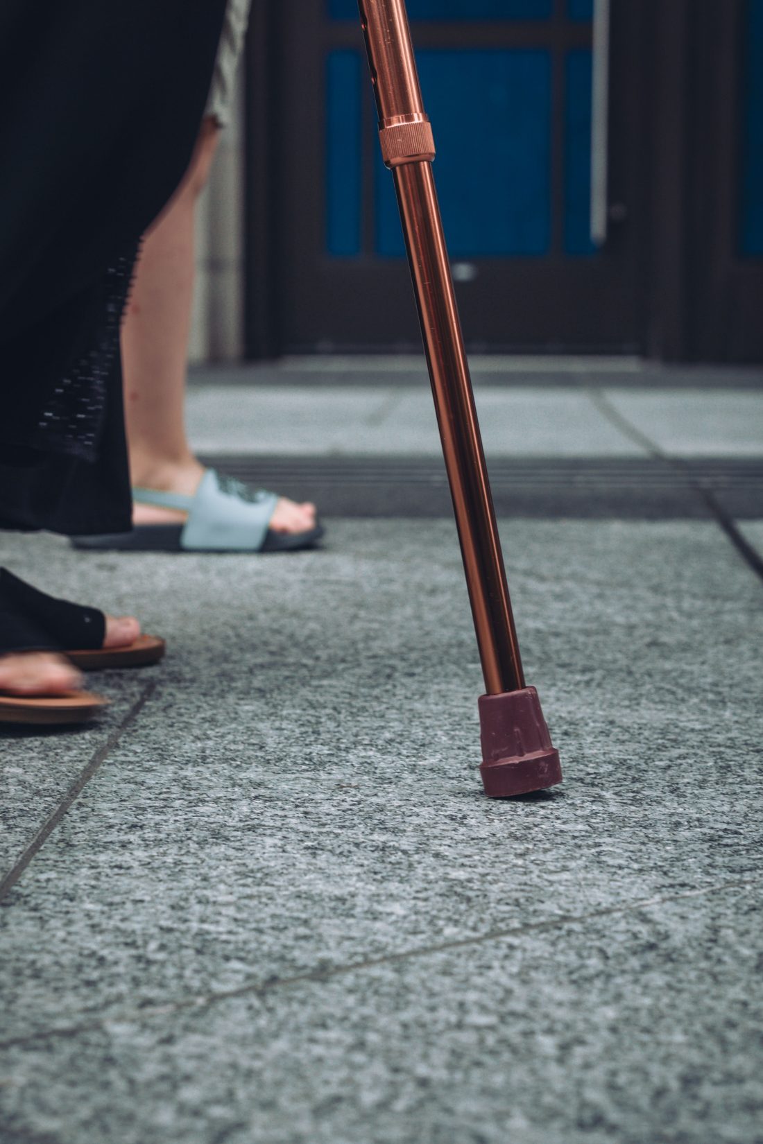 Close-up of a person's hand resting on the handle of a walking cane