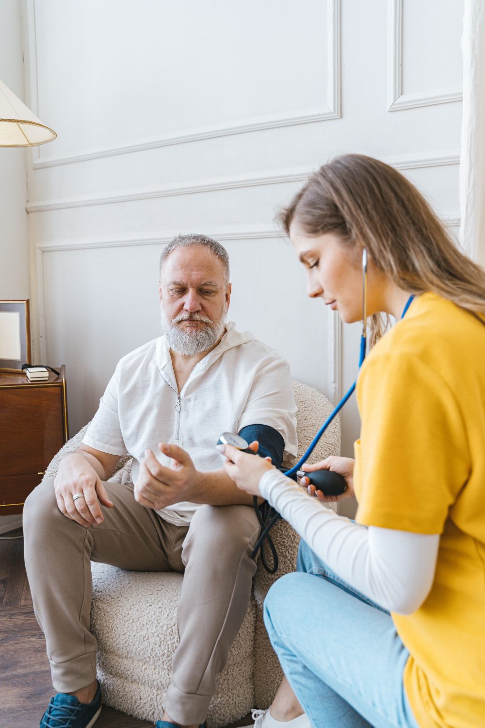 A healthcare provider checking a patient's blood pressure at home